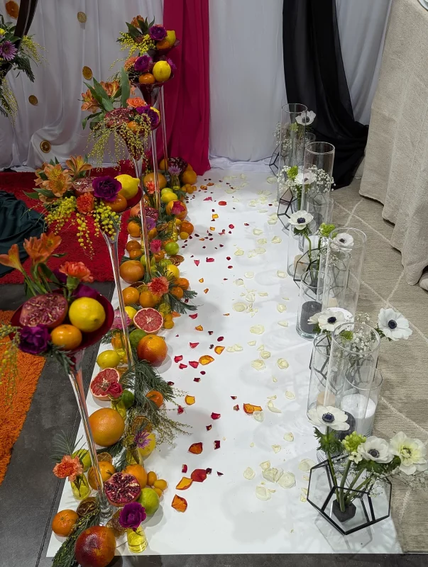 Decoration allee ceremonie style exotique et moderne avec vases de fruits, mimosa et anemones blanches.