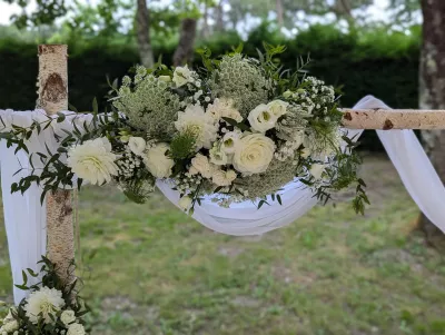 Arche florale champêtre pour cérémonie de mariage, avec dahlias, roses blanches, et feuillage vert au Domaine de Cordet, Arsac.