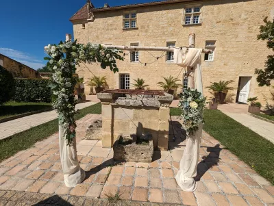 Arche florale champêtre pour cérémonie de mariage, décorée d'eucalyptus, de gypsophile et de roses blanches.