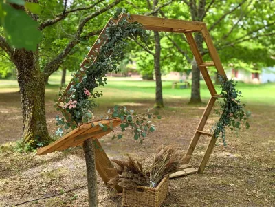 Arche florale hexagonale en bois avec eucalyptus, fleurs roses et herbes de pampa, style champêtre bohème mariage.