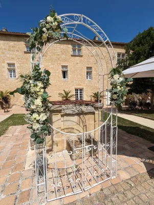 Arche florale champêtre pour cérémonie avec roses blanches, eucalyptus et gypsophile au Château Isabeau de naujan.