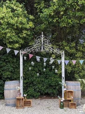 Arche florale champêtre pour photobooth avec eucalyptus, roses, gerberas roses et guirlandes, thème mariage.