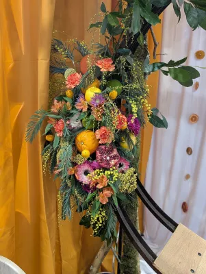 Exotic floral arch featuring citrus fruits, pomegranates, mimosa, roses and alstroemeria.