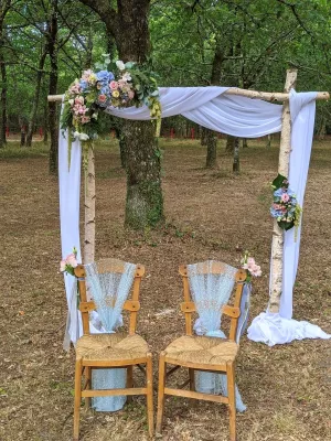 Arche florale champêtre pour cérémonie de mariage, avec hortensias bleus et roses pastel, roses et feuillage, au Domaine de la Forge.