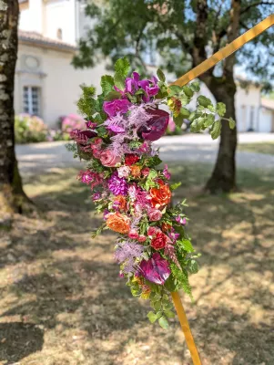 Geometric floral arch with purple orchids, orange roses and pink dahlias, sophisticated country style.