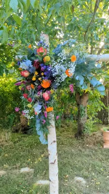 Asymmetrical sophisticated country-style floral arch with roses, delphiniums, and eucalyptus for Ilonna & Quentin's wedding.