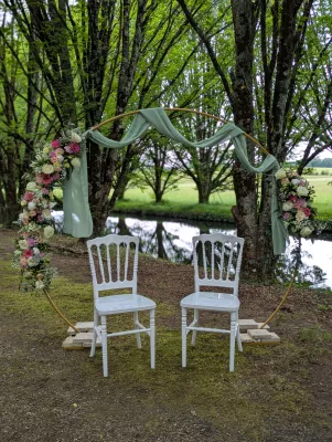 Arche florale champêtre sophistiquée avec roses, lisianthus et eucalyptus pour cérémonie extérieure.