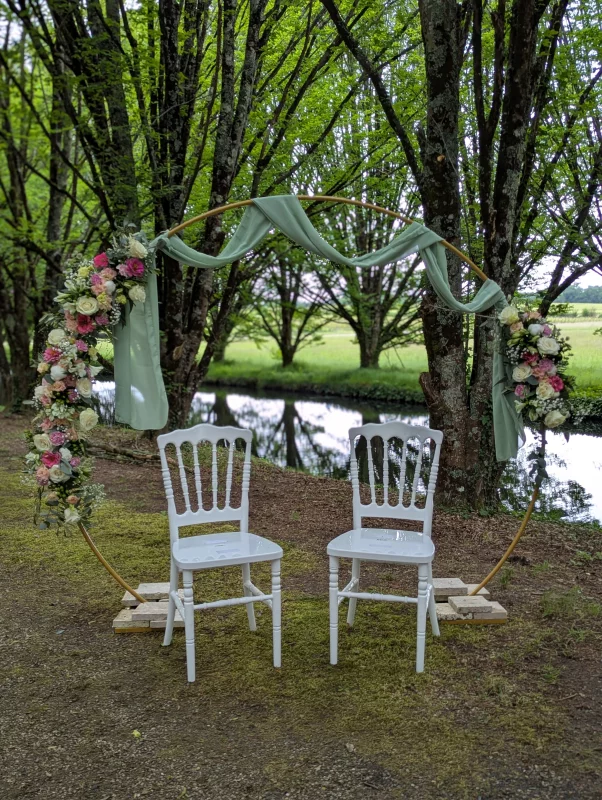 Sophisticated country-style floral arch with roses, lisianthus and eucalyptus for outdoor ceremony.