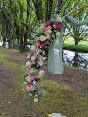 Détail d'arche florale champêtre sophistiquée avec roses, lisianthus et eucalyptus.