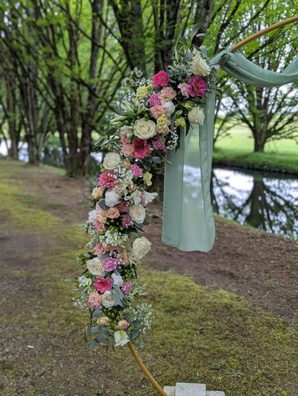 Detail of an elegant rustic floral arch featuring roses, lisianthus and eucalyptus.