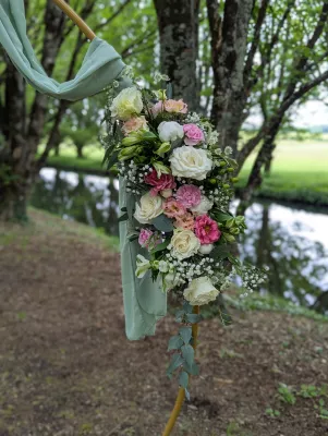 Détail d'arche florale champêtre sophistiquée avec roses, lisianthus et eucalyptus.