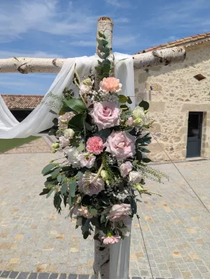Sophisticated country floral arch with roses, carnations, and eucalyptus for the wedding ceremony.