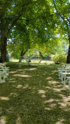 Arche florale champêtre sophistiquée avec roses, hortensias et eucalyptus pour une cérémonie en extérieur.