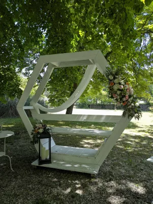 Arche florale champêtre sophistiquée avec roses, hortensias et eucalyptus pour une cérémonie en extérieur.