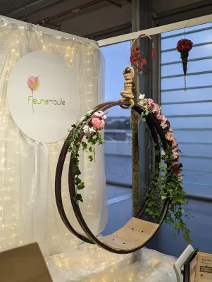 Arche florale circulaire avec roses et lierre, style bohème chic, idéale pour un photobooth ou coin romantique.