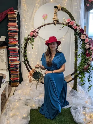 Photobooth floral avec arche ronde décorée de roses et lierre, style bohème romantique, pour le salon du mariage.