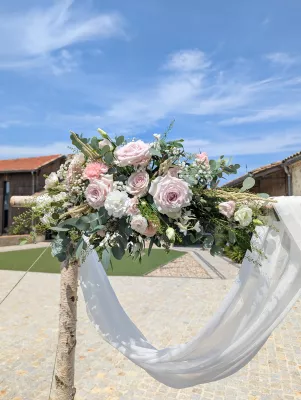 Close-up of a sophisticated country-style floral arch arrangement with roses and lisianthus.