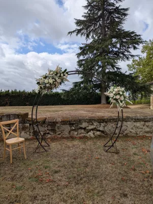 Arche florale de mariage bohème avec roses crème, pampa et eucalyptus, située au Grand Moueys Capian.