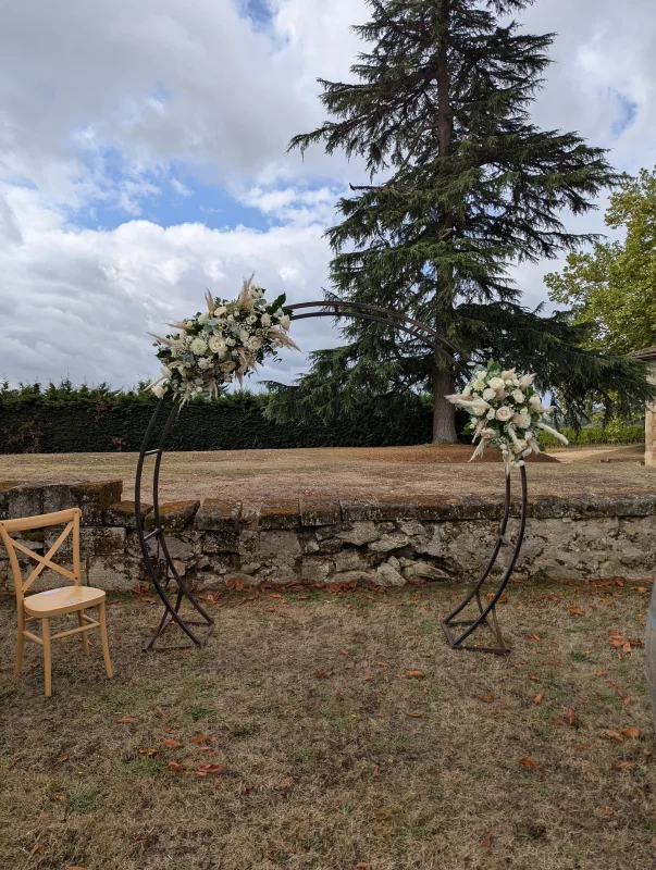 Bohemian wedding floral arch with cream roses, pampas and eucalyptus, located at Grand Moueys Capian.