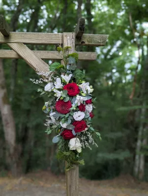 Gros plan sur composition florale champêtre de l'arche de mariage, avec roses, dahlias, alstroemeria et gypsophile.