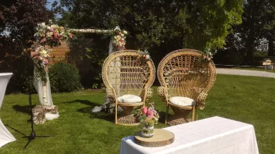 Arche florale champêtre pour cérémonie de mariage, avec roses pastel, œillets et feuillage vert luxuriant.