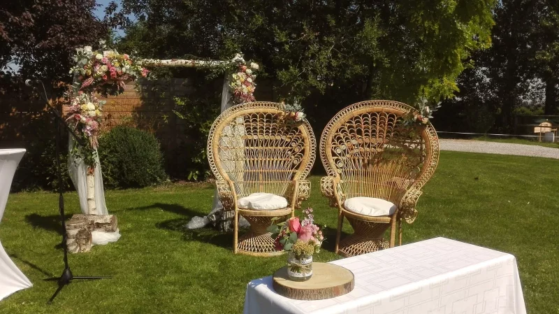 Arche florale champêtre pour cérémonie de mariage, avec roses pastel, œillets et feuillage vert luxuriant.