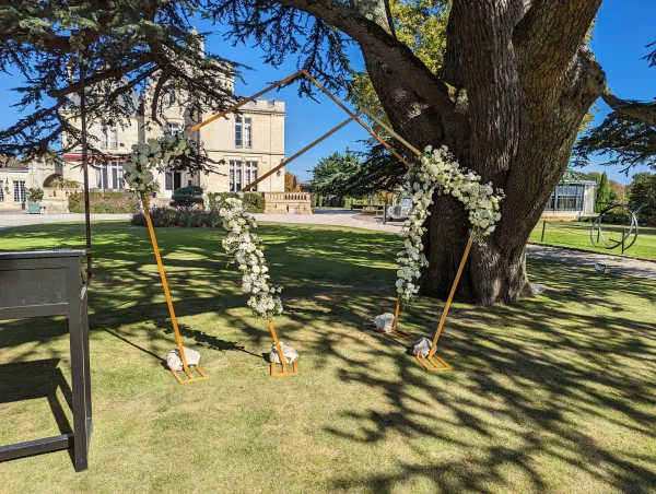 Deux arches florales modernes avec roses blanches, gypsophile et eucalyptus, décorant un mariage au Château Pape Clément.