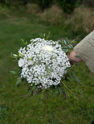 Petit bouquet a lancer style champetre pour mariage, composé de gypsophile blanc, roses blanches et feuillage vert.