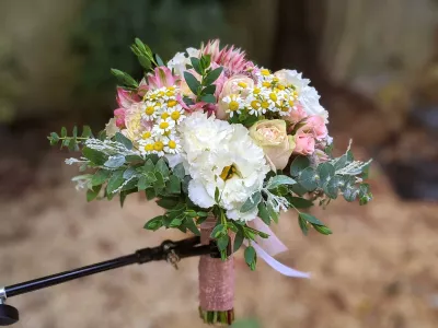 Bouquet de lancer champêtre avec marguerites, roses pâles et lisianthus blancs pour un mariage élégant et frais.