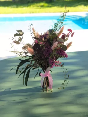 Petit bouquet à lancer champêtre avec pampa rose, eucalyptus et feuillages variés pour un mariage printanier.