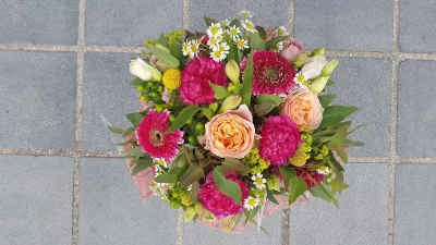 Bouquet à lancer de mariage champêtre, avec des roses pêches, des gerberas fuchsia, des marguerites et du craspedia jaune.