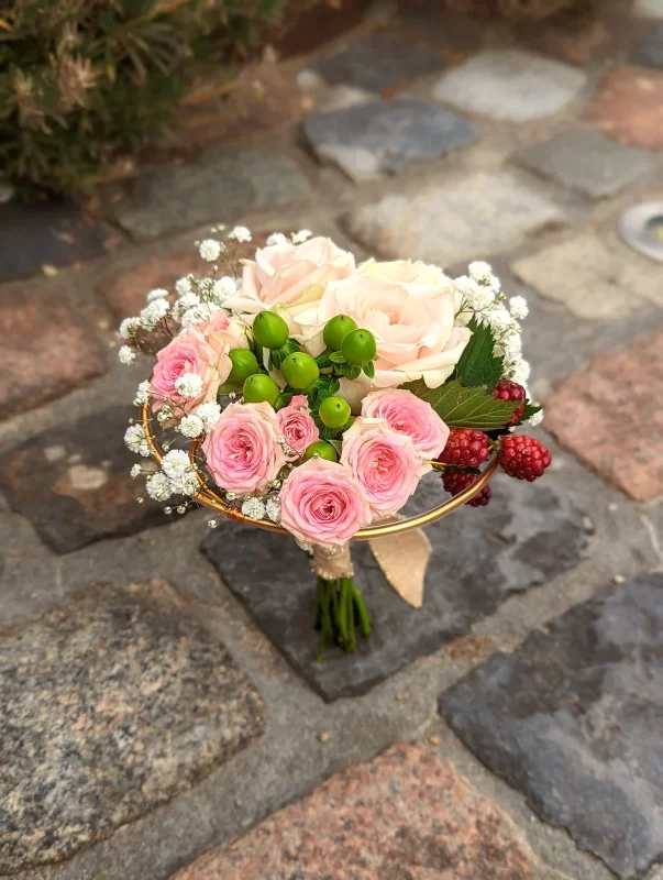 A rustic tossing bouquet featuring pink and cream roses, gypsophila and berries for a wedding in Saint-Medard-d'Eyrans.