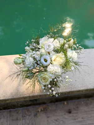 Bouquet à lancer champêtre et frais, composé de roses blanches, lisianthus et gypsophile pour un mariage d'été.