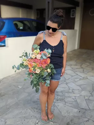 Bouquet de mariée bohème avec roses pêche et dahlias corail, feuillage eucalyptus, pour le mariage de Chrystelle au Grand Moueys.