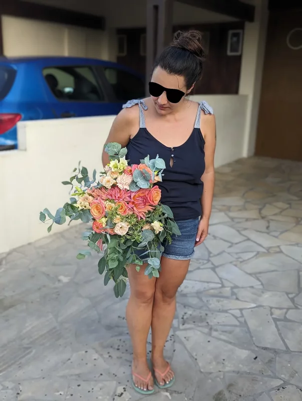 Bouquet de mariée bohème avec roses pêche et dahlias corail, feuillage eucalyptus, pour le mariage de Chrystelle au Grand Moueys.