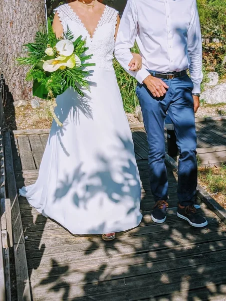 Superbe bouquet de mariée exotique avec des anthuriums d'un jaune très pâle, des orchidées blanches et un abondant feuillage tropical.