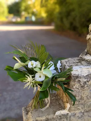 Bouquet de mariée exotique avec anthuriums, orchidées blanches, arums et feuillages tropicaux pour mariage.