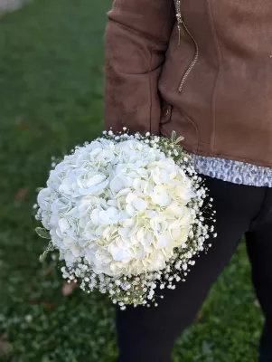 Bouquet de mariée bohème champêtre avec des hortensias blancs et du gypsophile, créant une ambiance naturelle et élégante pour le mariage.