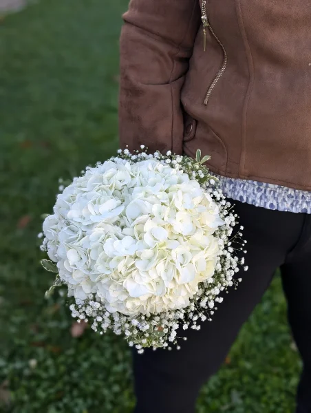 Bouquet de mariée bohème champêtre avec des hortensias blancs et du gypsophile, créant une ambiance naturelle et élégante pour le mariage.