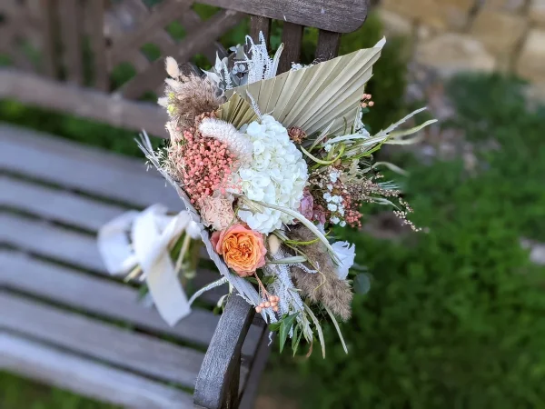 Bouquet de mariée bohème avec hortensia blanc, rose orange, pampa et palmier séché pour un mariage à Loubens.