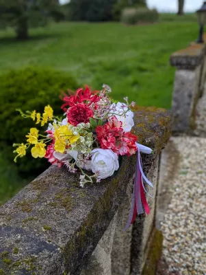 Bouquet de mariée exotique et classique avec orchidées jaunes, roses blanches et œillets rouges pour le mariage Sebastien.