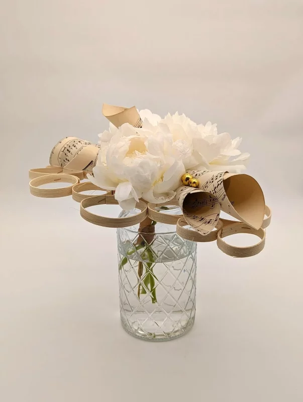 Exquisite minimalist bridal bouquet, featuring white peonies and delicate sheet music paper creations.