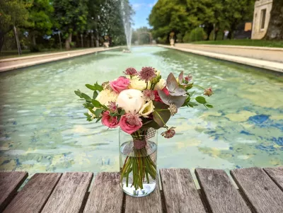 Bouquet de mariée champêtre avec pivoines blanches, roses crème et roses pâles, agrémenté d'eucalyptus et de fleurs bordeaux.