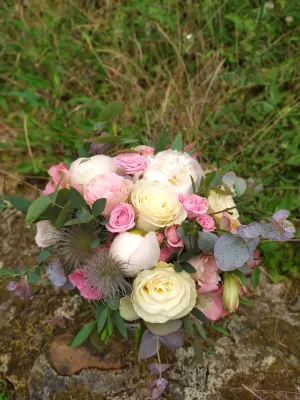 Magnifique bouquet de mariée champêtre avec pivoines blanches et roses, roses crème, eucalyptus, et chardon, pour un mariage estival.