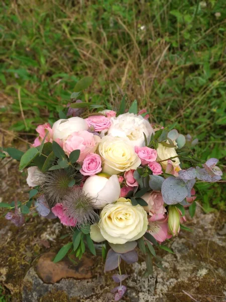 Magnifique bouquet de mariée champêtre avec pivoines blanches et roses, roses crème, eucalyptus, et chardon, pour un mariage estival.
