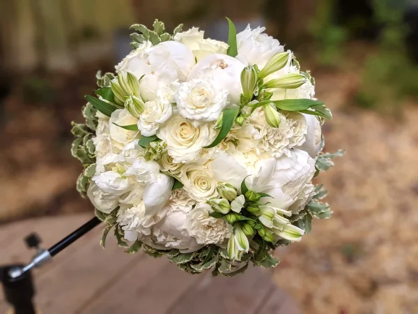 Bouquet de mariée champêtre rond et dense avec pivoines blanches, roses, alstroemeria et œillets, mariage à Plassac.