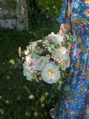 Bouquet de mariée classique avec des pivoines blanches, des roses pêche et de l'eucalyptus, pour un mariage au Chateau Bel'Ange à Sainte-Bazeille.