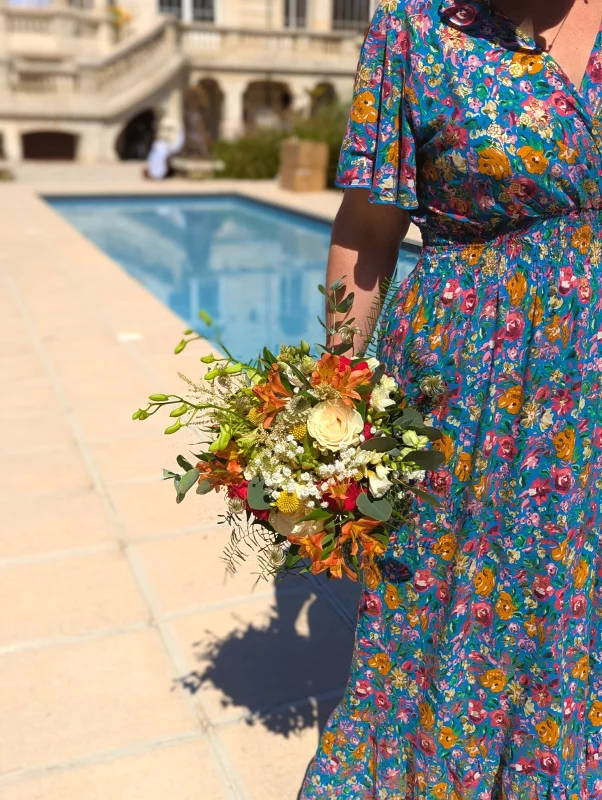 Romantic organic bridal bouquet with cream roses, orange alstroemerias and grey-green foliage