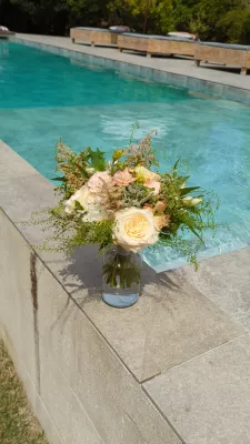Bouquet de mariée champêtre et romantique avec roses crème, astilbe rose, alstroemeria et feuillage vert frais.