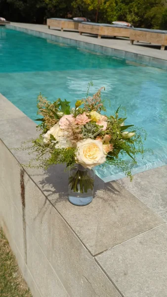 Bouquet de mariée champêtre et romantique avec roses crème, astilbe rose, alstroemeria et feuillage vert frais.